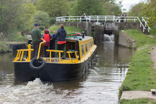 A Family Steers Their Boat Towards The Lock At Hirst Wood Watched By Bystanders