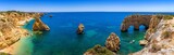 Fototapeta Morze - Natural caves at Marinha beach, Algarve Portugal. Rock cliff arches on Marinha beach and turquoise sea water on coast of Portugal in Algarve region.