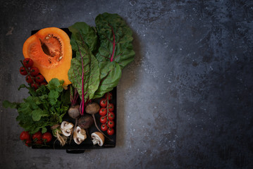 Wall Mural - Vegetables on vintage gray background. Autumn harvest. Organic food background. Farmers vegetable market. Seasonal fall vegetables. Rural still life from above with free text space. Toned image.