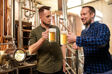 Two men tasting fresh beer in a brewery