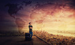 canvas print picture - Man dreamer standing with suitcase on the rooftop of a skyscraper planning his next holiday destination