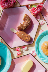 Wall Mural - Donuts and ice-cream on plates with dianthus petals