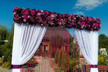 Wall Mural - Beautiful wedding arch for the ceremony in the garden in sunny weather.