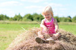 © jordano - Happy baby girl laughing on summer haystack