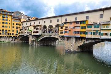 Wall Mural - Ponte Vecchio or Old Bridge is a medieval stone bridge over the Arno River, in Florence, Italy. It's noted for having shops on in. Photos taken right after the rain as the sun was coming out.