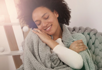 Touch of softness.Young woman enjoying softness of her cozy knitted sweater