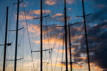Sailing Ship Masts And Rigging Against A Cloudy Sky At Sunset.