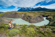 © Westend61 - Chile, Patagonia, woman using tablet at a river bend in Torres del Paine National Park