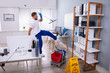 Young Man Slipping While Mopping Floor In The Office