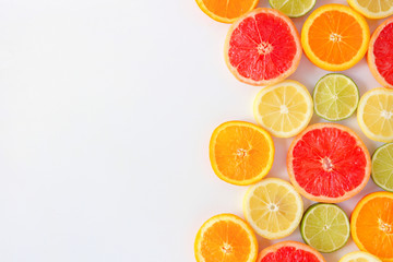 Sticker - Colorful fruit side border of fresh citrus slices. Top view, flay lay over a white background with copy space.