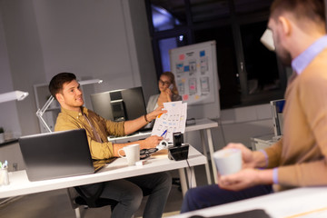 Wall Mural - business, deadline and technology concept - software developers discussing user interface design mockup at night office