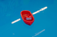 Red Plastic Toy Boat Floating In The Water
