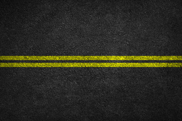 Structure of granular asphalt. Asphalt texture with two yellow line road marking. Abstract road background.