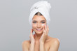 © arttim - Beautiful young girl with a towel on her head uses face cream