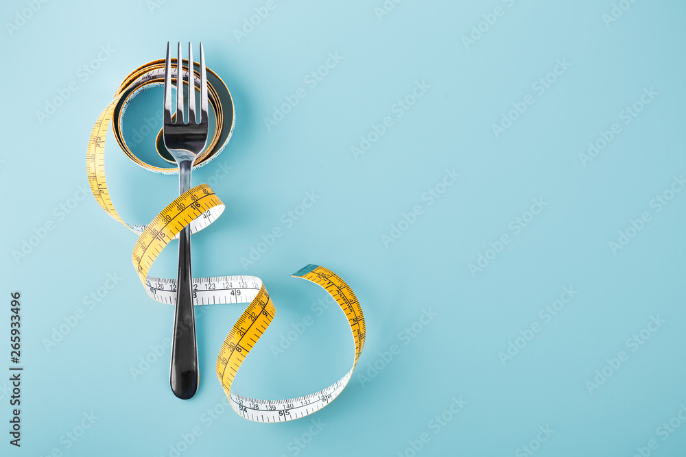 Fork with measuring tape around, diet background - obrazy, fototapety, plakaty 