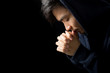 © christianchan - Praying Man Against Dark Background With Copy Space