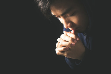 Wall Mural - Praying Man Against Dark Background With Copy Space