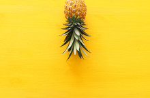 Ripe Pineapple Over Yellow Wooden Background. Beach And Tropical Theme. Top View