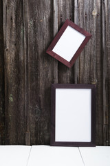 blank picture frames on old weathered wooden wall background