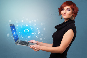 Wall Mural - Woman holding laptop projecting notifications, symbols and information based on cloud technology system
