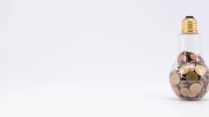 Wall Mural - stop motion shot of light bulb and coins isolated on white background. energy savings concept.