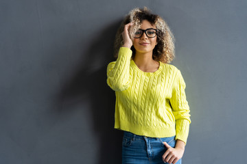 Wall Mural - Portrait of young beautiful cute cheerful black girl smiling looking at camera over gray background.