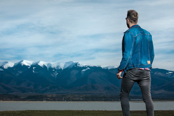 Wall Mural - back view of a young casual man  admiring the view