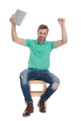 Wall Mural - seated modern man celebrates victory with hands up