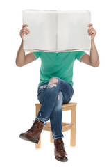 Poster - seated man covering his face behind a newspaper