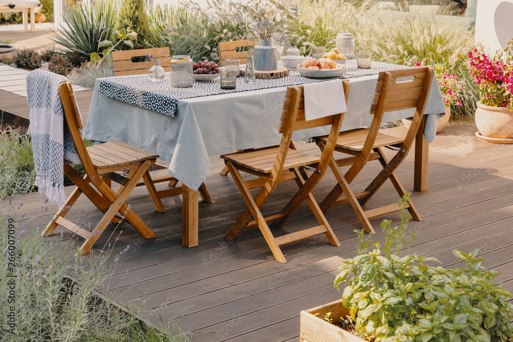 Real photo of a dining table with wooden chairs set on the terrace ...