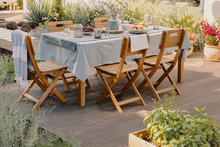 Real Photo Of A Dining Table With Wooden Chairs Set On The Terrace