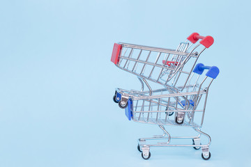 Empty grocery cart on wheels on a blue background