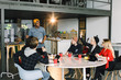© sofiko14 - African american man in casual wear standing near the glass office wall with financial points, explaining planning and business strategies to colleagues, creative solutions on brainstorming session
