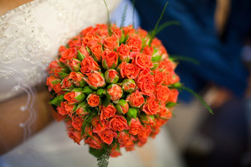 Wall Mural - A luxurious bouquet of coral roses in the hands of the bride