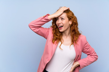 Wall Mural - Redhead woman in suit over isolated blue wall has realized something and intending the solution