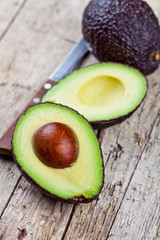 Canvas Print - Fresh organic avocado and knife on old wooden table background. Fresh avocado halves on rustic wooden backround.