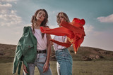 Fototapeta Tulipany - High fashion portrait of two stylish beautiful woman in trendy jackets and jeans posing outdoor. Vogue style.
