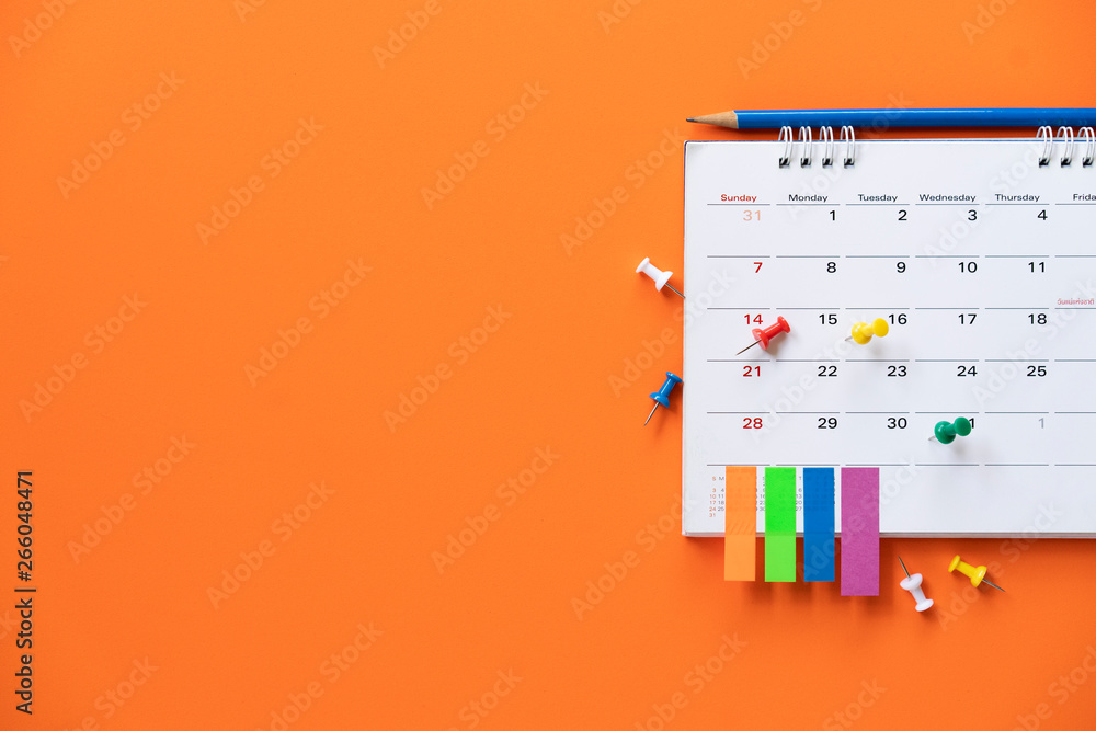 close up of calendar on the orange table background, planning for business meeting or travel planning concept - obrazy, fototapety, plakaty 