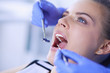 © lenets_tan - Young Female patient with open mouth examining dental inspection at dentist office.