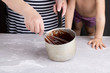 © Данияр Айбеков - daughter and profesional cook are stirring the flour with a whisk