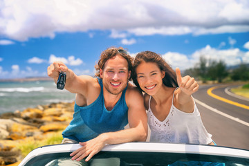 Wall Mural - Road trip travel couple showing car keys on summer vacation. Happy young people adventure lifestyle. Carsharing, rideshare, autostop car young adults buying new car, rental insurance young people.