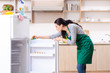 © Elnur - Young woman cleaning fridge in hygiene concept
