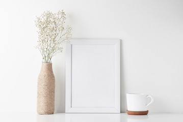 Wall Mural - Mock up with empty frame, cup and flower in bottle vase on white background.