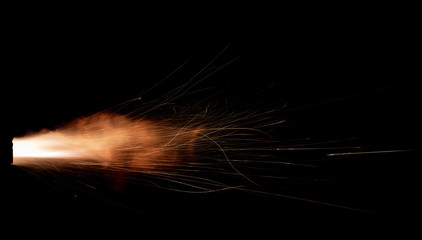 Wall Mural - Texture of firearm shot with bright flash of light, sparks, smoke and gunpowder gases on black background