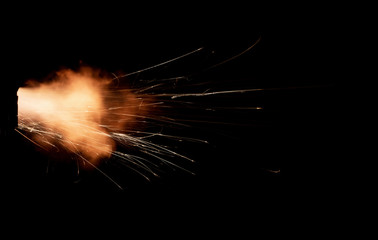 Wall Mural - Texture of firearm shot with bright flash of light, sparks, smoke and gunpowder gases on black background