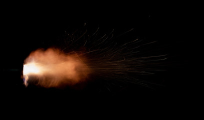 Wall Mural - Texture of firearm shot with bright flash of light, sparks, smoke and gunpowder gases on black background
