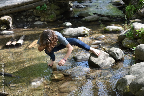 Fotomural Barefoot boy exploring stream or creek
