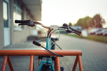 Girl Teenager Fastening Bicycle Lock On Street Parking At Sunset
