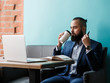 © Ilnur - Young serious bearded businessman working on computer at table,drinking coffee.Man analyzes information, data, develops business plan. Freelancer, entrepreneur.Online marketing, education, e-learning