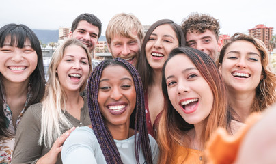 Happy friends from diverse cultures and races taking photo making funny faces - Youth, millennial generation and friendship concept with young people having fun together